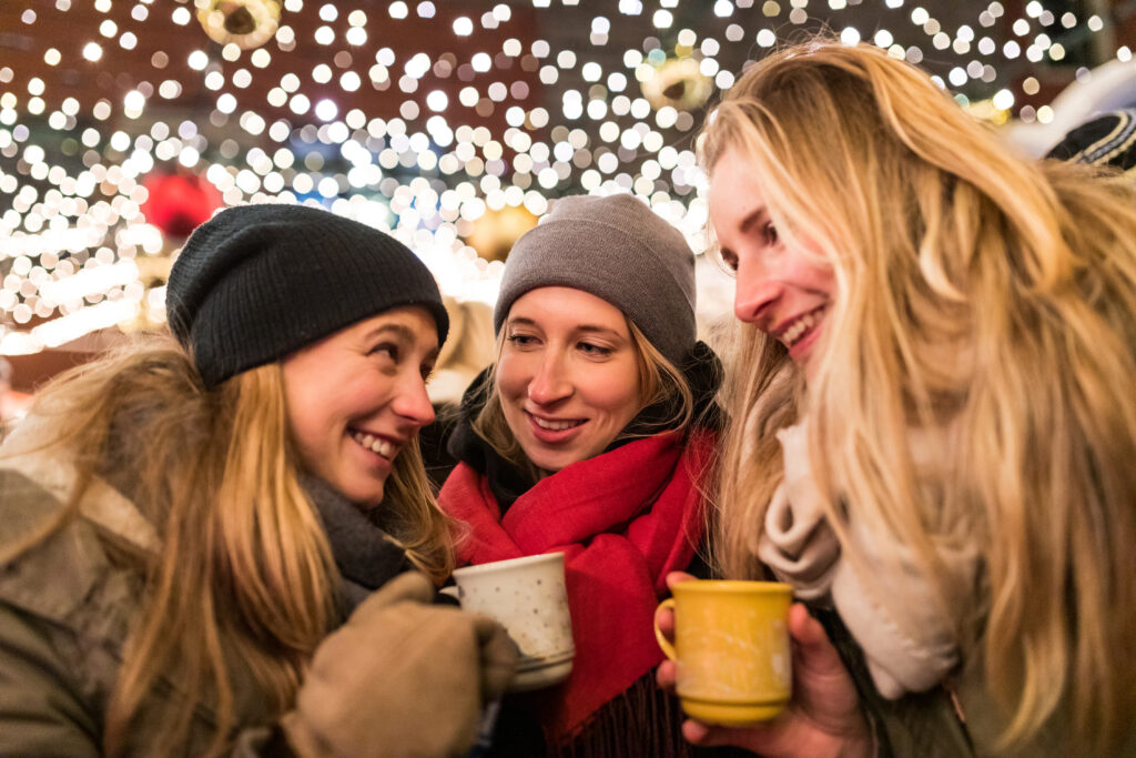 Drei Frauen auf dem Weihnachtsmarkt am Neumarkt mit Glühwein