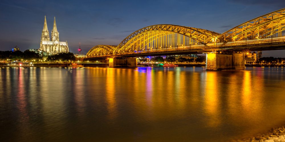 Night View of Cologne Cathedral (Kolner Dom) and Rhine river under the Hohenzollern Bridge, Cologne city skyline at night, North Rhine Westphalia region, Germany.
