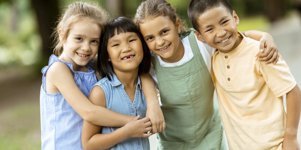 Group of cute asian and caucasian kids having fun in the park